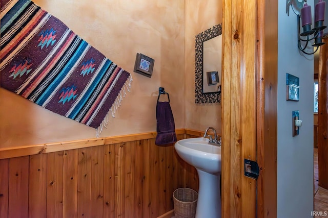 bathroom featuring sink and wood walls