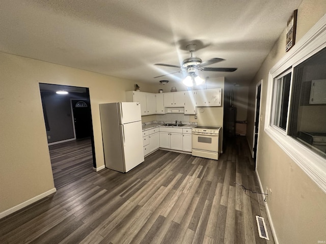 kitchen featuring white appliances, dark wood-type flooring, sink, a textured ceiling, and white cabinetry