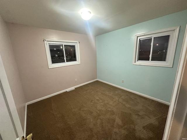 empty room featuring dark colored carpet