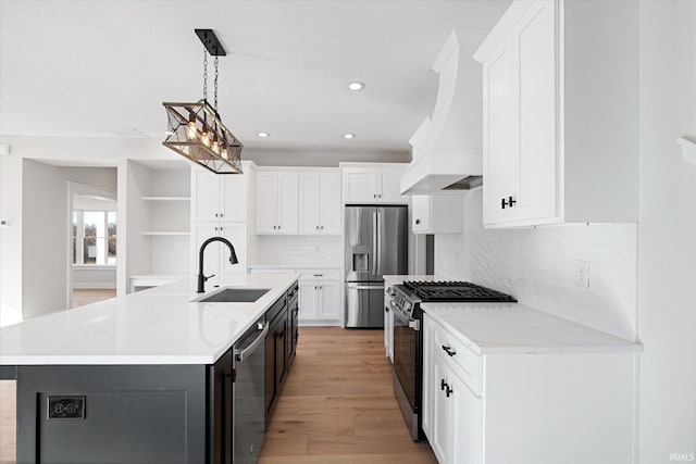 kitchen featuring custom range hood, stainless steel appliances, white cabinetry, and an island with sink