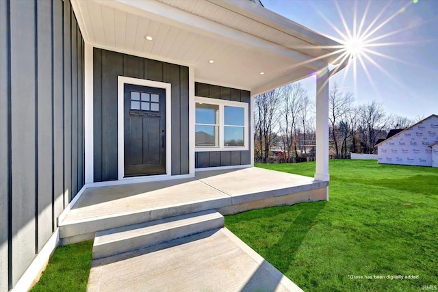 doorway to property with a yard and covered porch