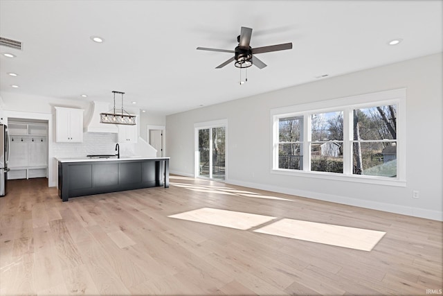 kitchen featuring white cabinetry, hanging light fixtures, a healthy amount of sunlight, and a large island