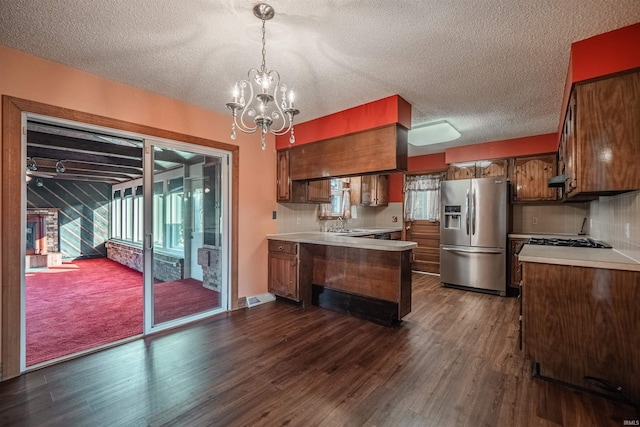 kitchen with tasteful backsplash, stainless steel fridge with ice dispenser, dark hardwood / wood-style flooring, and pendant lighting