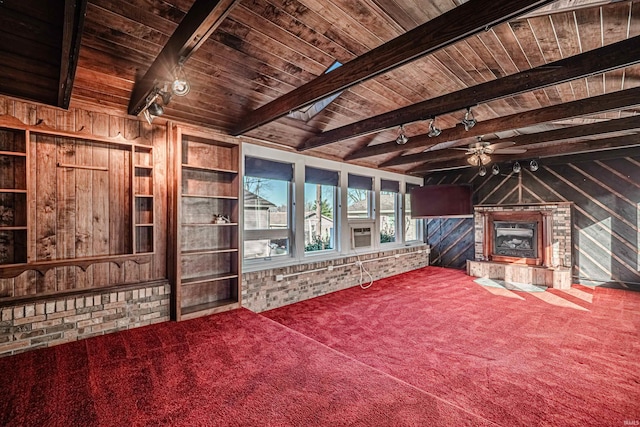 unfurnished living room featuring beamed ceiling, carpet floors, ceiling fan, and wooden ceiling