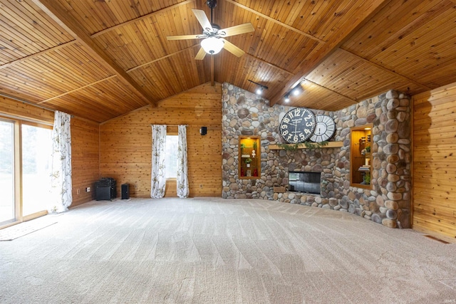 unfurnished living room with ceiling fan, wood walls, wooden ceiling, and carpet floors