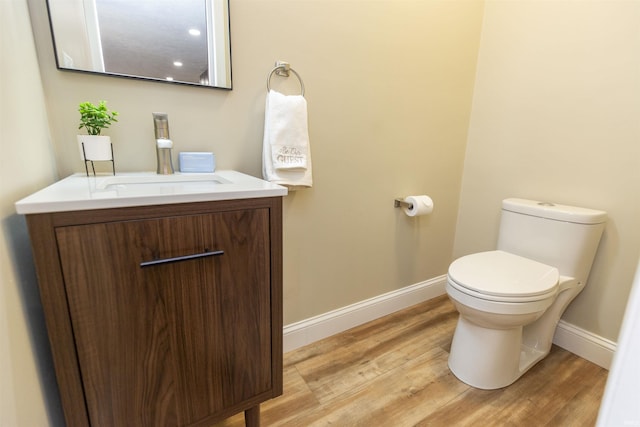 bathroom with hardwood / wood-style floors, vanity, and toilet