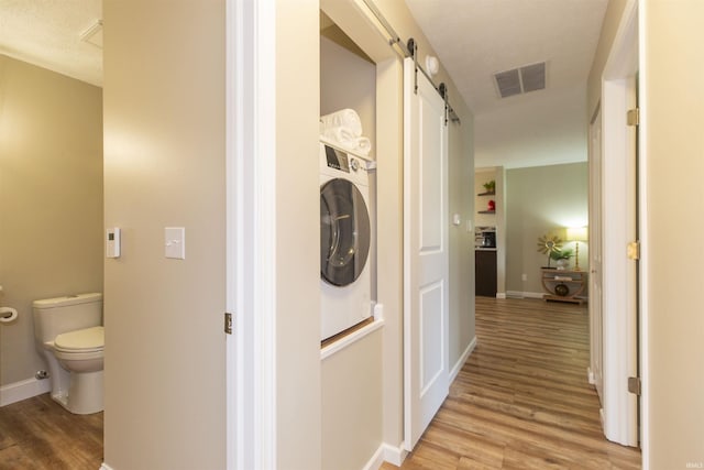 washroom featuring a barn door, light wood-type flooring, and washer / clothes dryer