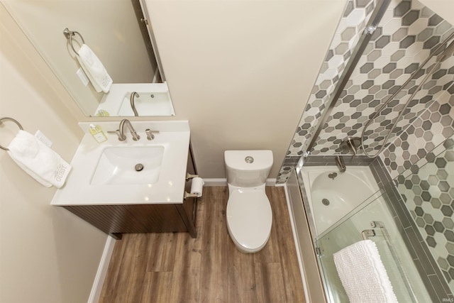 bathroom with toilet, vanity, an enclosed shower, and hardwood / wood-style flooring