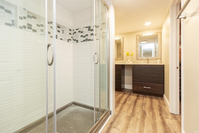 bathroom featuring vanity, wood-type flooring, walk in shower, and ornamental molding