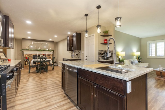 kitchen with dishwasher, a center island, hanging light fixtures, sink, and light hardwood / wood-style floors