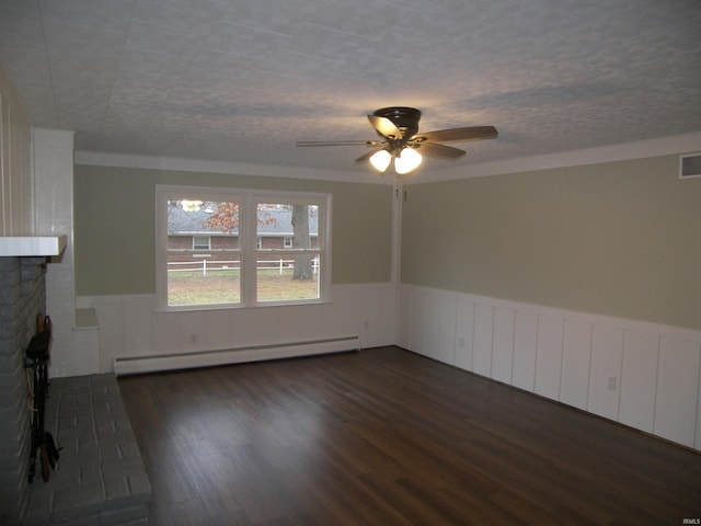 unfurnished living room with crown molding, ceiling fan, a fireplace, a baseboard radiator, and dark hardwood / wood-style flooring