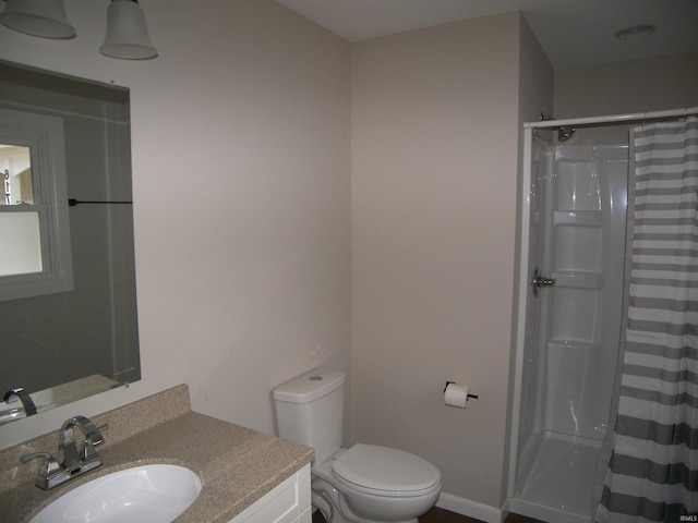 bathroom with toilet, vanity, and a shower with shower curtain