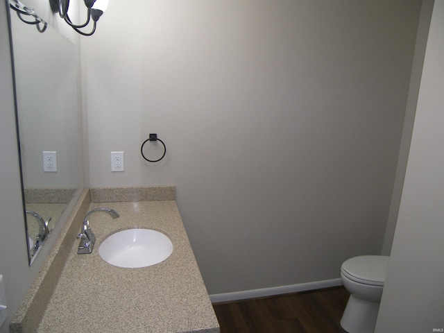 bathroom featuring toilet, vanity, and hardwood / wood-style flooring