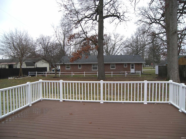 wooden terrace featuring a lawn and a trampoline