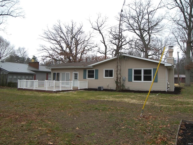 rear view of house with cooling unit, a yard, and a wooden deck