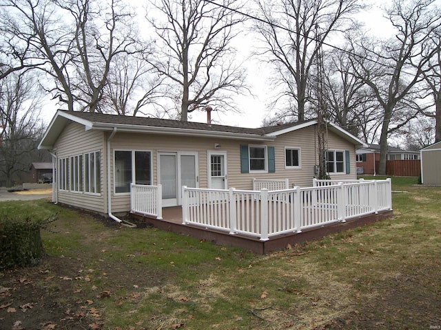 rear view of house with a deck and a yard