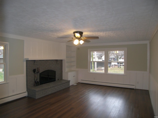 unfurnished living room with a brick fireplace, dark hardwood / wood-style floors, ceiling fan, and a baseboard radiator