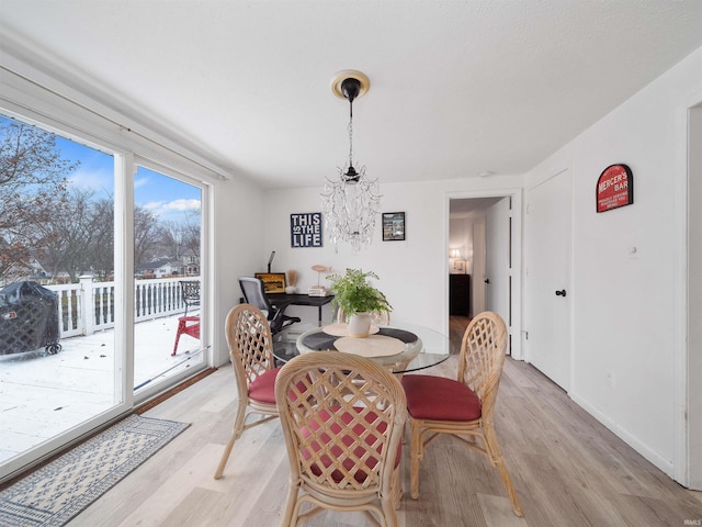 dining space featuring an inviting chandelier and light hardwood / wood-style flooring