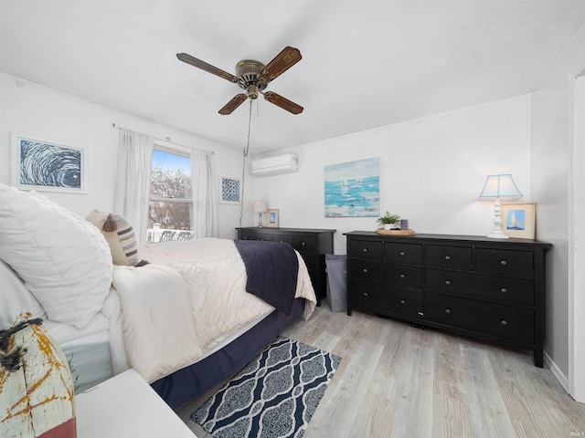 bedroom with light wood-type flooring, ceiling fan, and an AC wall unit