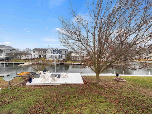 view of dock featuring a yard, a water view, and a patio