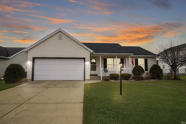 ranch-style home featuring a lawn, covered porch, and a garage