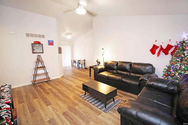 living room with hardwood / wood-style flooring, vaulted ceiling, and ceiling fan