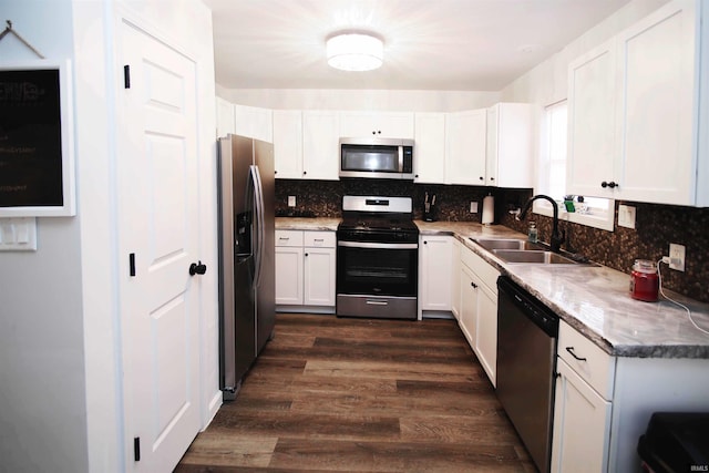 kitchen with white cabinetry, sink, stainless steel appliances, dark hardwood / wood-style flooring, and backsplash