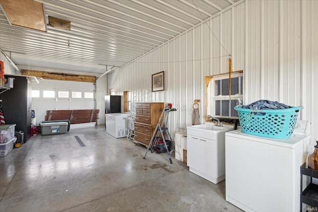 garage featuring washing machine and dryer and sink