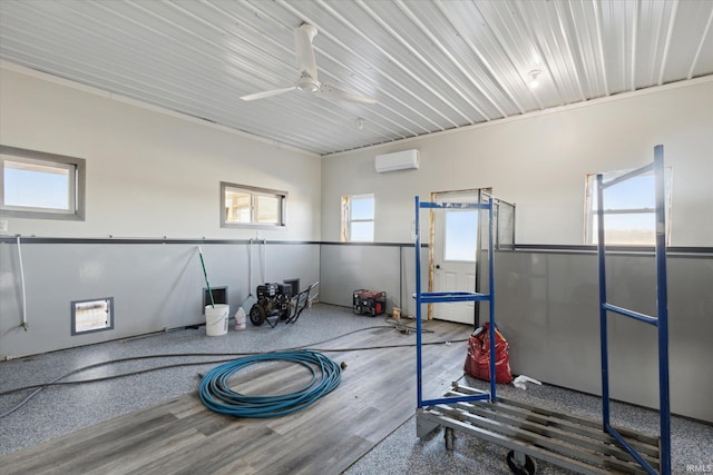 exercise area with hardwood / wood-style flooring, ceiling fan, a wealth of natural light, and a wall mounted AC