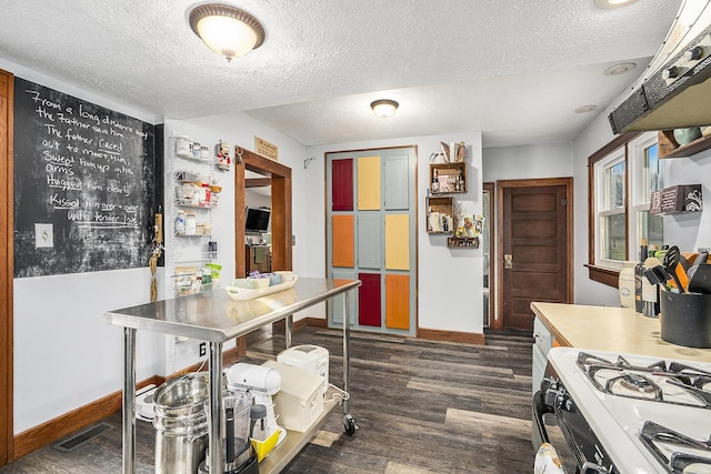 kitchen featuring dark hardwood / wood-style flooring, a textured ceiling, and white gas range oven