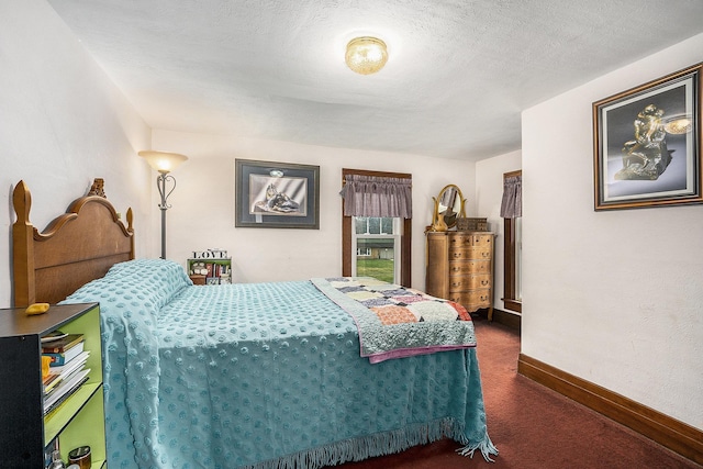 bedroom with dark carpet and a textured ceiling