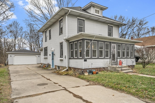 view of property featuring an outbuilding, a garage, a front lawn, and a sunroom