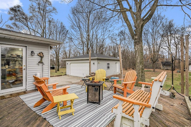 deck with an outdoor fire pit, an outbuilding, and a garage