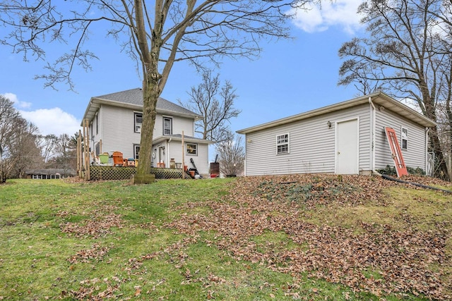 back of house with a deck and a lawn