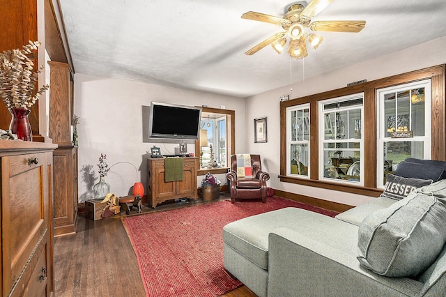 living room featuring ceiling fan and dark hardwood / wood-style floors