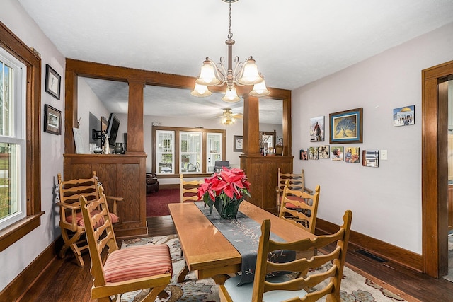 dining area featuring a healthy amount of sunlight, dark hardwood / wood-style flooring, and a chandelier