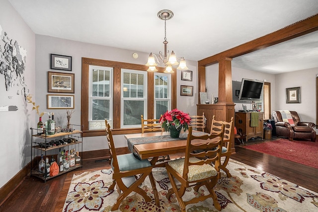 dining area featuring dark hardwood / wood-style flooring and a chandelier