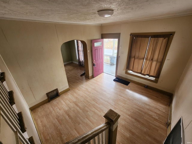 entryway with a textured ceiling and light hardwood / wood-style flooring