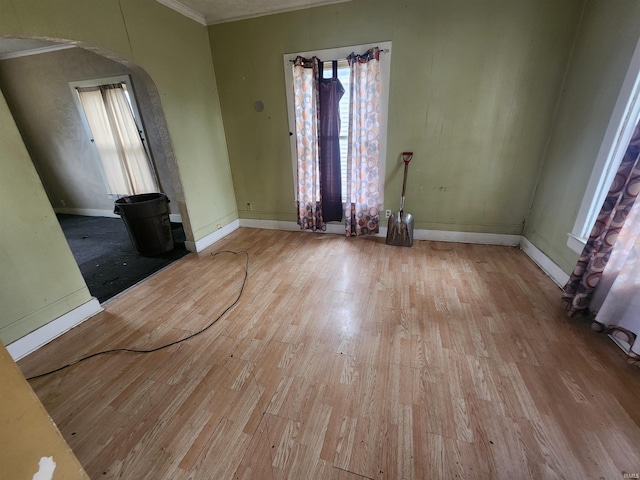 interior space featuring crown molding, plenty of natural light, and light wood-type flooring