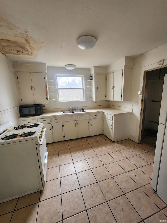 kitchen with sink, white cabinets, white appliances, and light tile patterned floors