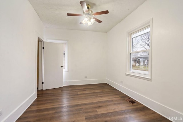 unfurnished room featuring dark hardwood / wood-style floors, ceiling fan, and a textured ceiling