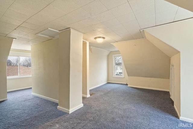 bonus room featuring vaulted ceiling and dark colored carpet