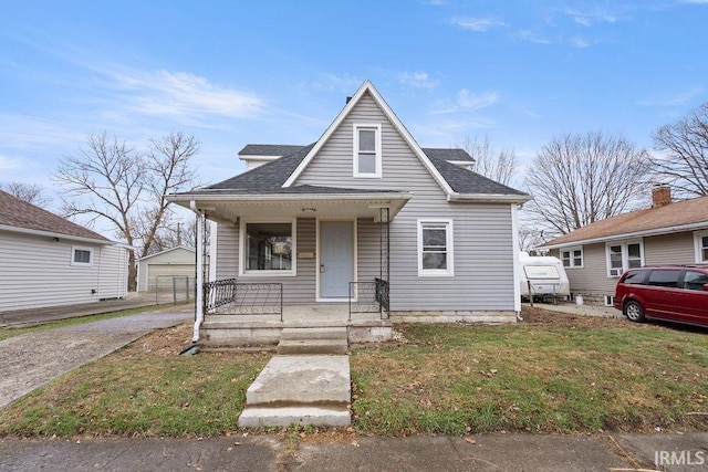 bungalow featuring an outdoor structure, a garage, a porch, and a front yard