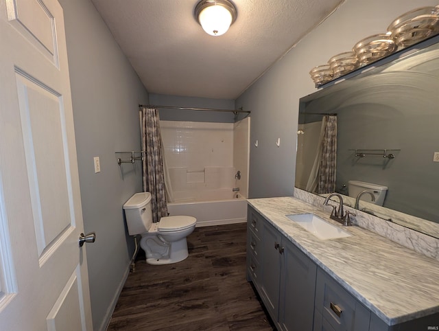 full bathroom with a textured ceiling, toilet, shower / bath combo with shower curtain, vanity, and hardwood / wood-style flooring