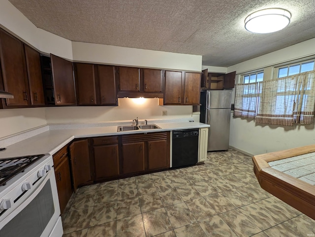 kitchen with sink, a textured ceiling, black dishwasher, white gas stove, and stainless steel refrigerator