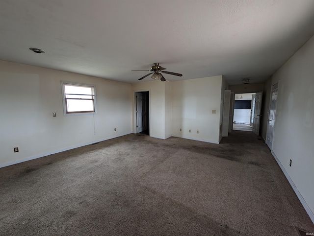 unfurnished room featuring dark colored carpet and ceiling fan