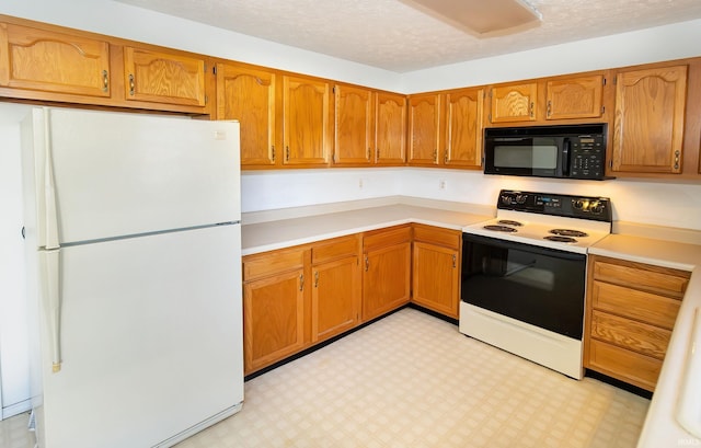 kitchen featuring a textured ceiling and white appliances