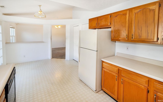 kitchen with pendant lighting, white refrigerator, and black dishwasher