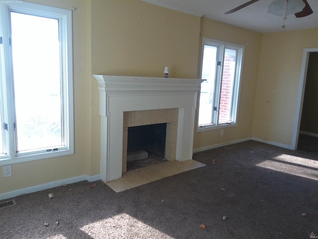 unfurnished living room with a fireplace, carpet, and ceiling fan