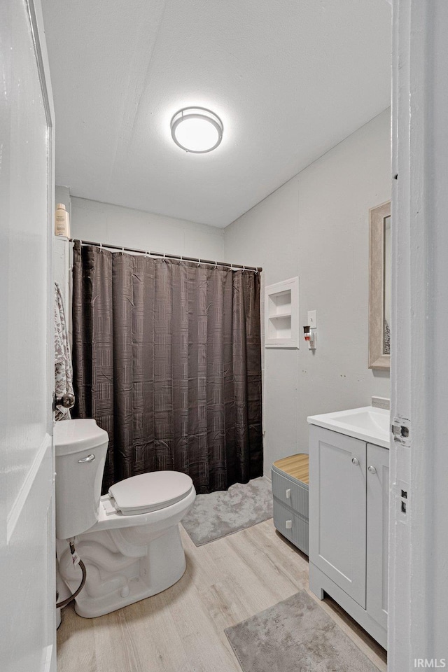 bathroom featuring hardwood / wood-style flooring, vanity, toilet, and a shower with curtain